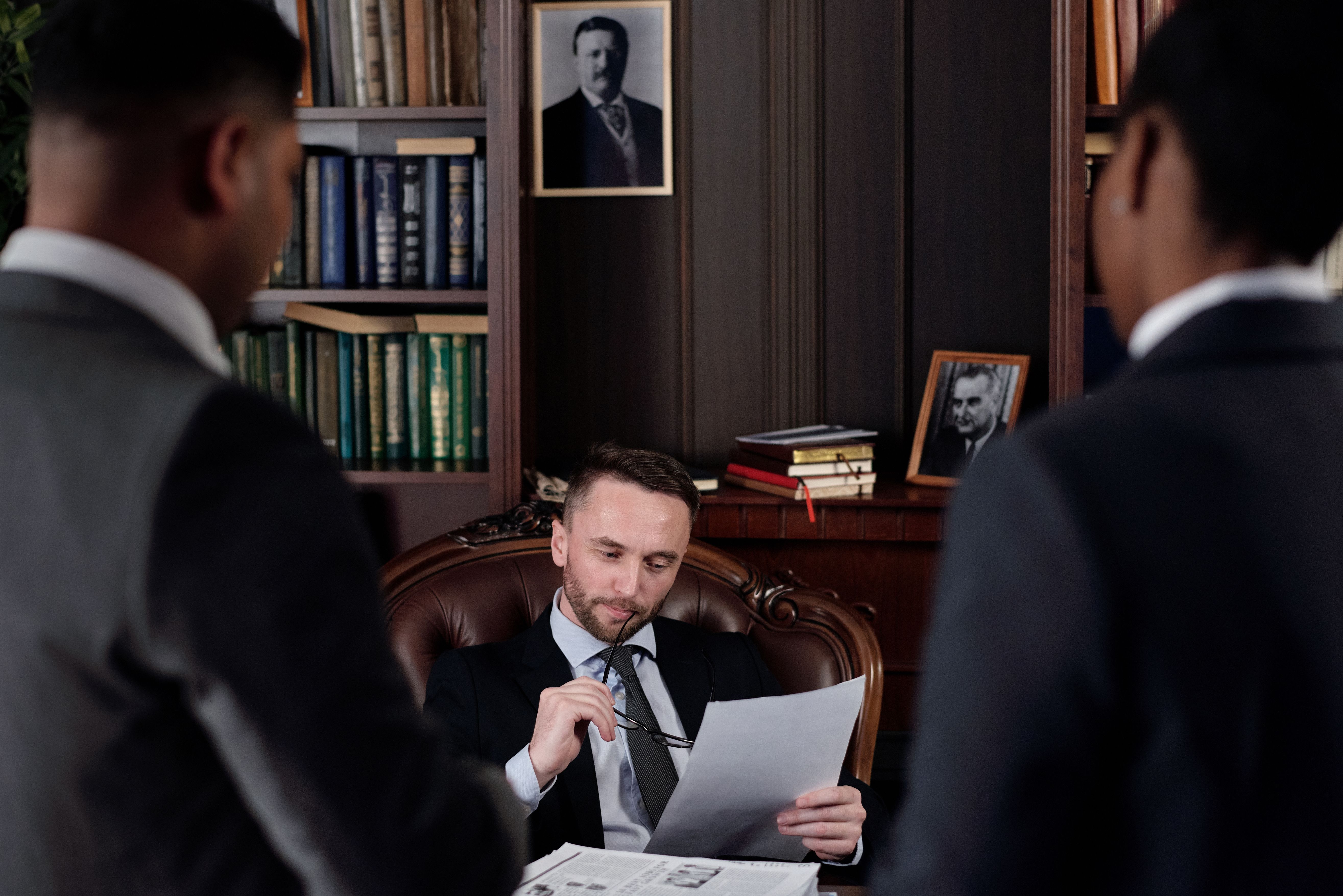 Attorneys in a serious consultation behind a classic law library desk