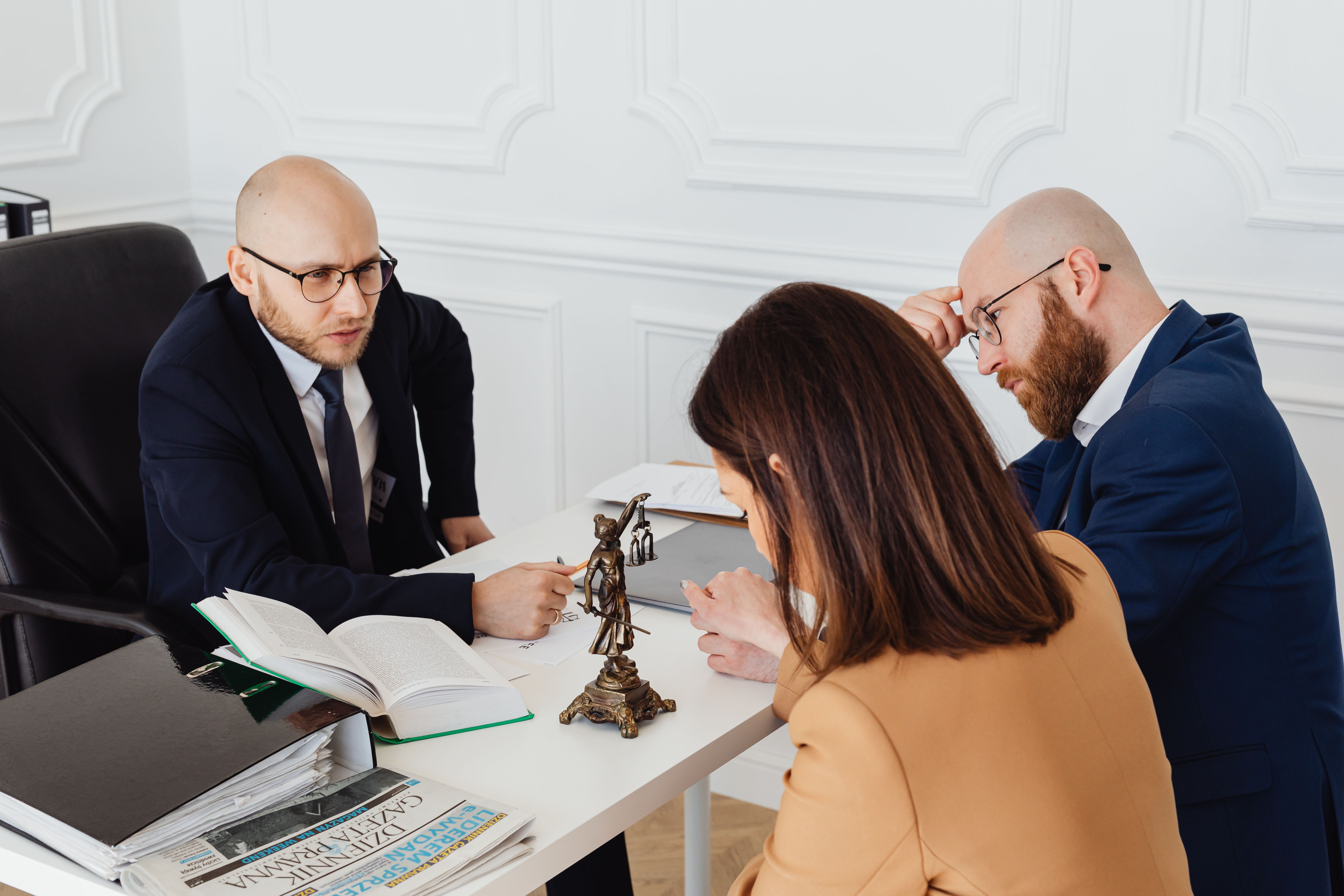 A lawyer consulting with a couple across a desk in a modern office