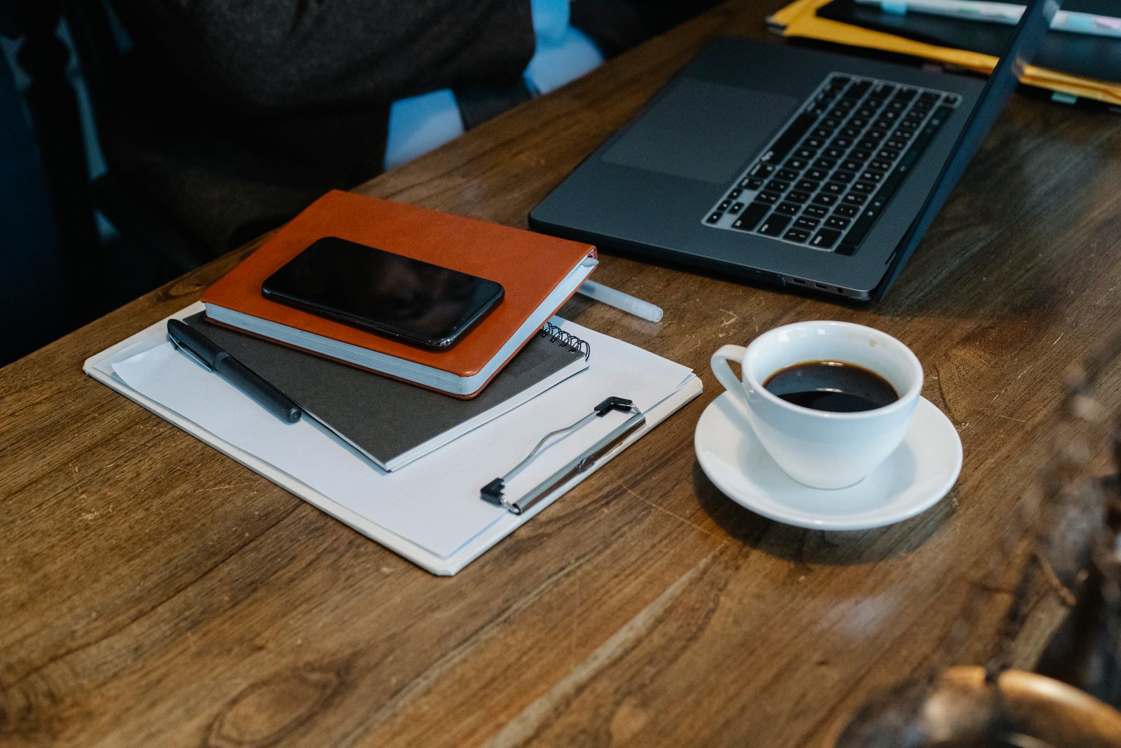 Laptop and coffee cup on a wooden desk, seen from above