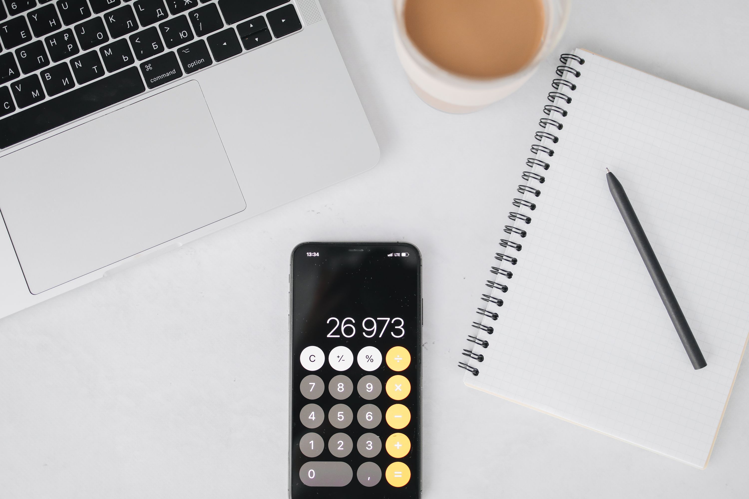 Laptop and phone calculator on a desk for budget planning
