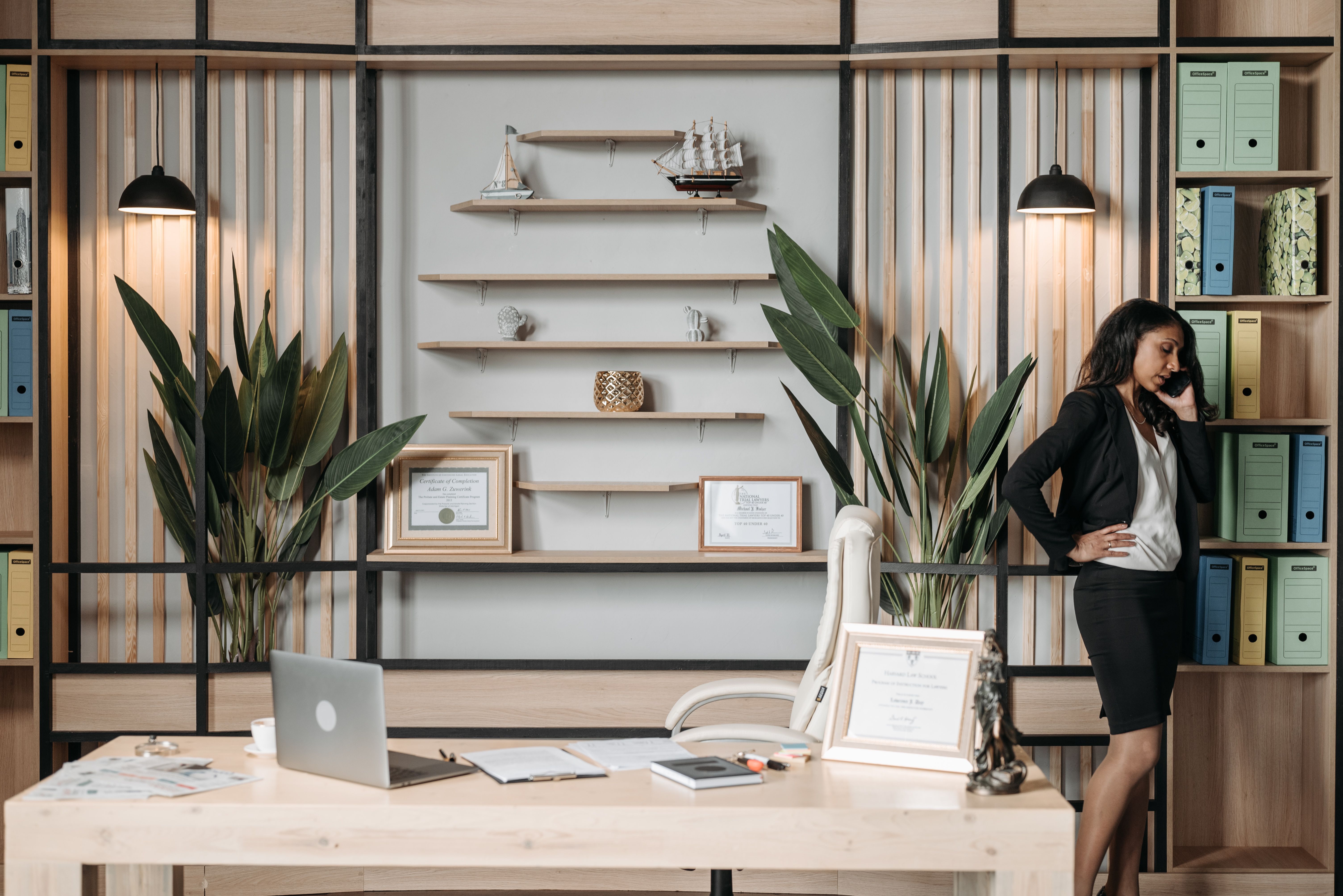 Attorney taking a phone call at her office desk while reviewing an inquiry